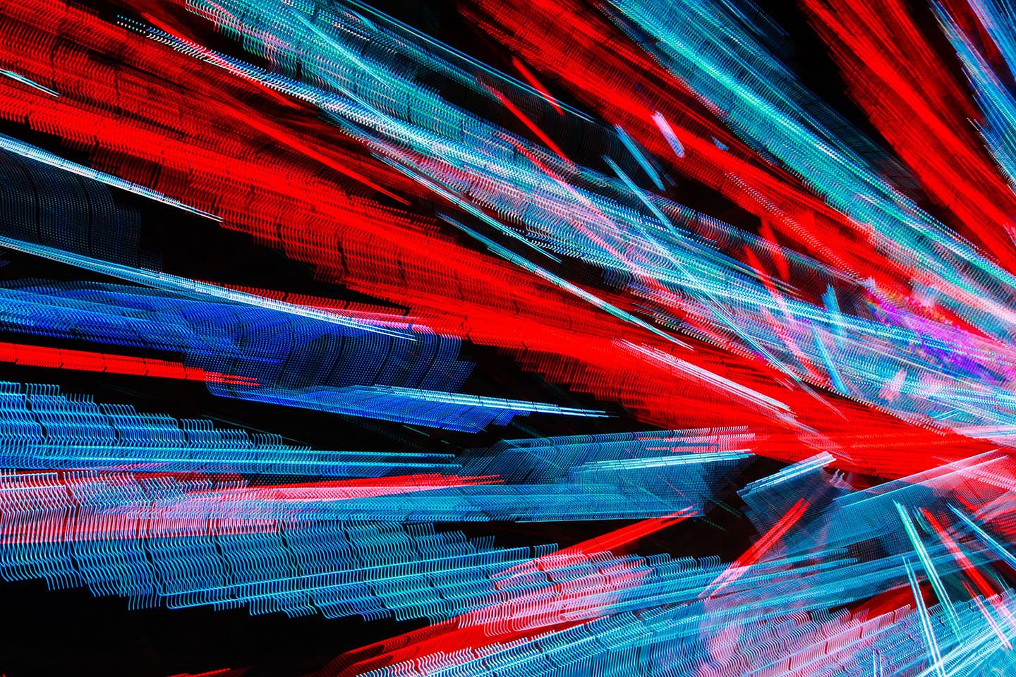 Abstract photograph of blue and red vibrant colors moving at high speed in the same direction, looking like data being transferred through a wire